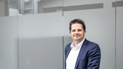 Person mit blauem Blazer vor Glaswand