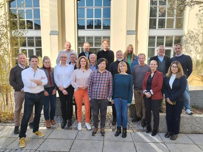 Menschen vor einem Gebäude mit gelber Fassade 