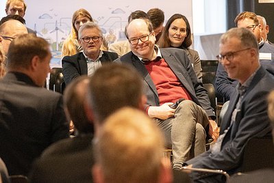 Personen sitzen nebeneinander und diskutieren über etwas