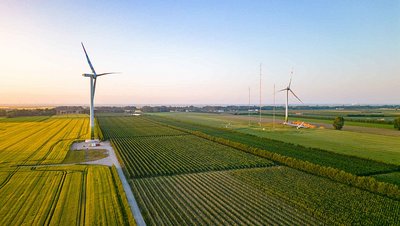 Zwei Windturbinen auf einer grünen Wiese bei klarem Himmel