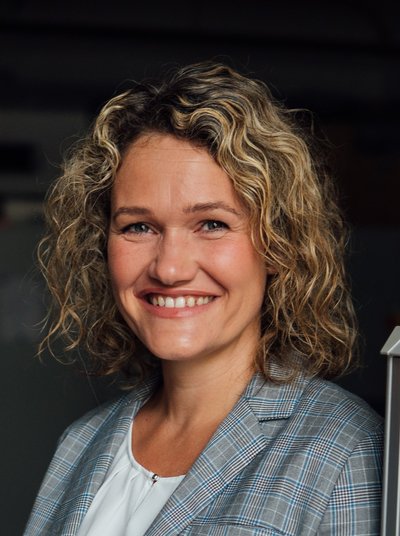 Eine Frau mit lockigen Haaren lächelt