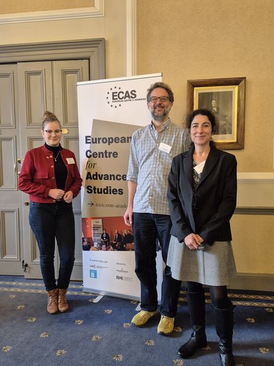 Zwei Frauen und ein Mann vor einem Roll up