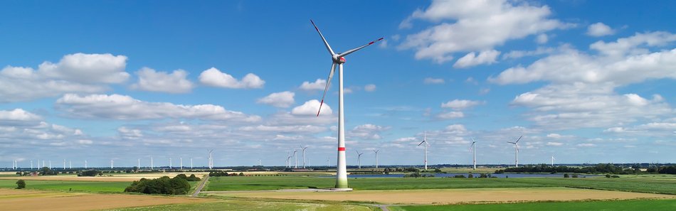 Windräder vor blauem Himmel mit Wolken