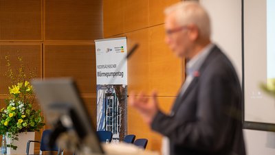 eine Person spricht bei einer Veranstaltung in das Mikrofon
