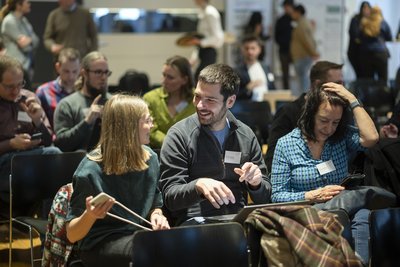 Eine Fau und ein mann unterhalten sich inmitten eines großen bestuhlten Raumes