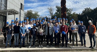 Gruppe von Personen mit blauen Schutzhelmen stehen nebeneinander