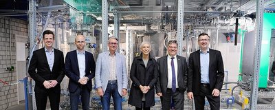 Personen stehen vor einer Anlage